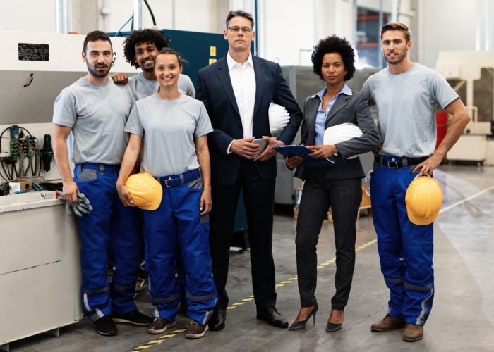 Portrait of company leaders and their employees in industrial plant.