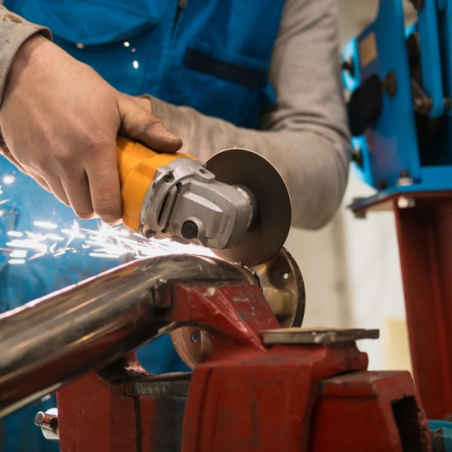 Technician worker cutting metal with many sharp sparks. Using equipments to cat iron